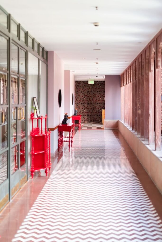 Luxurious hotel corridor in Rajasthan featuring red decor and refined design.
